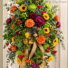Large standing floral spray with sunflowers, roses, and chrysanthemums