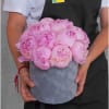 Pink peonies arranged in a gray hatbox