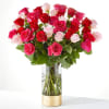 Bouquet of red, pink, and white roses in a clear glass vase