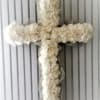 White floral cross on a ribbed gray background