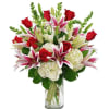 Bouquet of red roses, pink lilies, and white hydrangeas in a glass vase