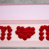 Pink gift box with red roses arranged in the letters M and N and a heart