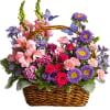 Mixed pink and purple flowers in a wicker basket with butterfly picks