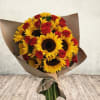 Bouquet of sunflowers and red roses wrapped in brown paper