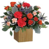 Orange and red roses with carnations in a wooden cube vase