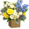 Bouquet of white roses, yellow blooms, and blue flowers in a wooden box