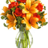 Orange lilies and red roses in a clear glass vase