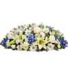 White and blue floral casket spray with lilies, roses, and daisies