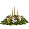 Holiday centerpiece with three gold candles and white flowers