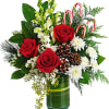 Red roses and white flowers in a green glass vase with candy canes