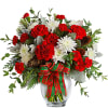 Red carnations and white chrysanthemums in a glass vase with a plaid ribbon