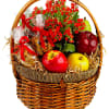 Basket of red flowers with fruit and wrapped snacks