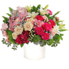 Mixed bouquet of pink and white flowers in a white vase