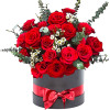 Red roses arranged in a black hatbox with a red ribbon