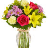 Mixed bouquet of pink roses, yellow lilies, and daisies in a glass vase