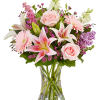 Pink and white mixed flowers arranged in a clear glass vase