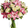 Pink lilies and white roses arranged in a clear glass vase
