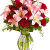 Pink lilies and red roses in a clear glass vase