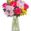 Bouquet of pink roses and daisy-like flowers in a clear glass vase