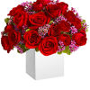 Red roses with pink filler flowers in a white box vase