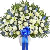 White lilies and roses in a vase with a blue ribbon