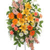 Standing floral spray with yellow lilies, orange daisies, and pink carnations