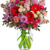 Mixed pink and red flowers in a clear glass vase