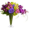Colorful bouquet of roses, hydrangeas, and orchids in a tall glass vase
