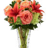 Pink roses and red lilies in a clear glass vase