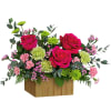 Pink roses and carnations in a wooden box with green accents