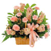 Pink flowers arranged in a wicker basket with a satin ribbon