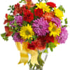 Colorful mixed bouquet in a clear glass vase with a yellow ribbon