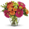 Bouquet of orange roses and pink gerbera daisies in a clear glass vase