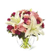 Pink roses and white lilies in a clear glass vase