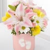 Pink and yellow flower arrangement in a pink box with baby footprints