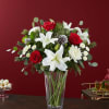 Red roses and white lilies arranged in a clear glass vase