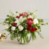 Red and white floral arrangement in a round glass vase