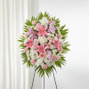 Pink and white funeral spray on a standing easel