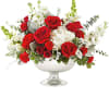 Red roses and white flowers arranged in a silver pedestal bowl
