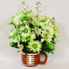 Green and white daisy bouquet in a football-shaped mug vase