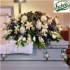 Large white and purple funeral spray on a casket