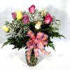 Bouquet of multicolored roses with baby's breath in a glass vase