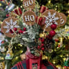 Christmas arrangement in a red candle jar with HO HO HO signs and ornaments