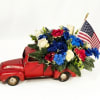 A playful vintage-red toy truck overflowing with silk red, white &amp; blue