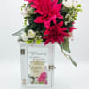 Pink and white floral arrangement on a white memorial lantern