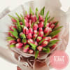 Bouquet of pink tulips wrapped in pale paper