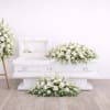White floral funeral casket spray with matching standing arrangement