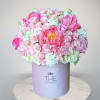 Pink and white flower arrangement in a lavender hat box