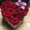 A heart-shaped box filled with roses and topped with an orchid.

SUBSITUTION POLICY
In