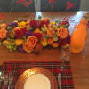 A table arrangement of fall flowers and fruit.  Perfect for a